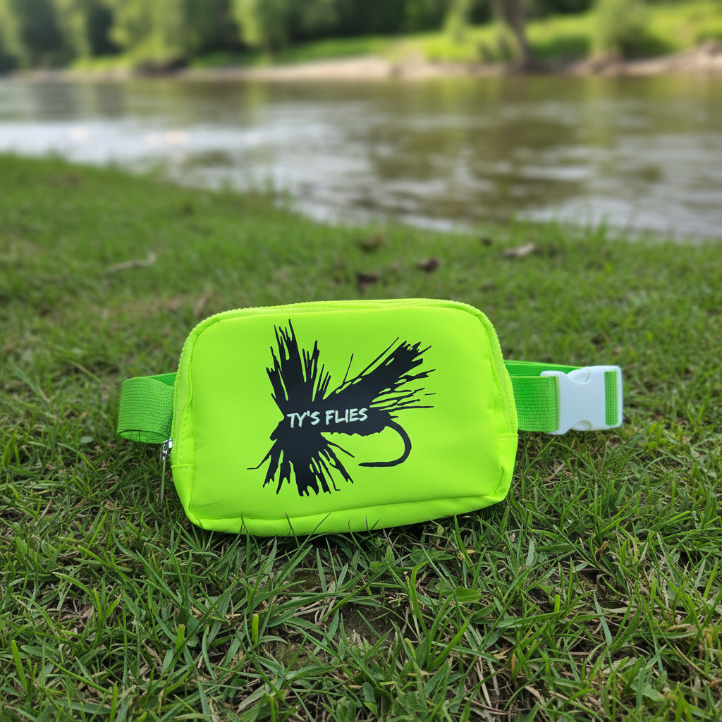 florescent yellow belt bag set along a grassy river bank
